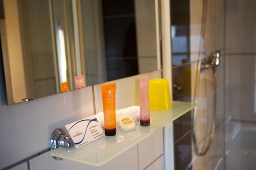 een badkamerplank met twee tandenborstels en een spiegel bij Das Ostseehotel in Hohwacht