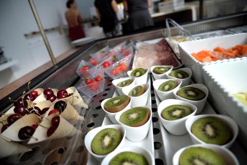 a tray of food with kiwis and fruit in cups at Hotel Byron in Rimini