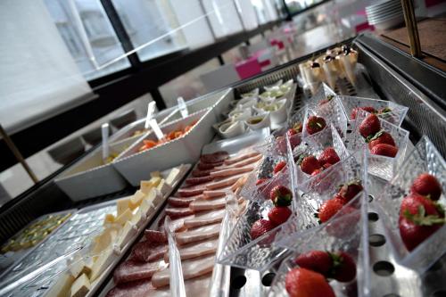 a buffet line of food with strawberries and other foods at Hotel Byron in Rimini