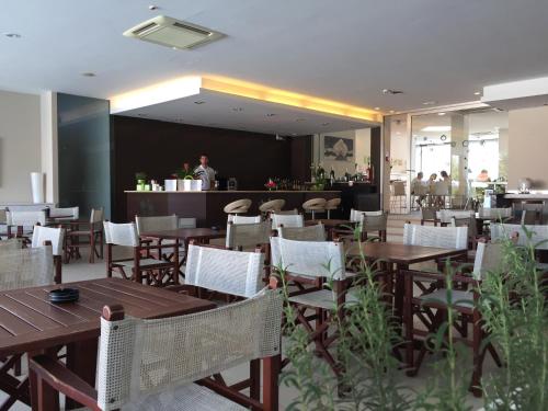 a restaurant with wooden tables and chairs and a bar at Hotel Byron in Rimini