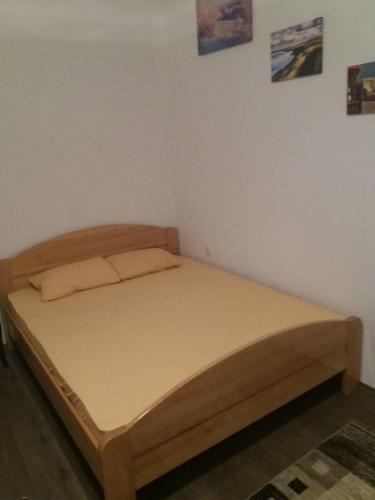 a bed in a room with a wooden bed frame at Rooms Adrijana in Banja Luka