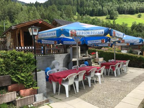 a group of tables and chairs with umbrellas at Hotel Haus Mühlebach in Ernen