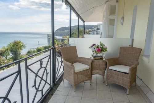 a balcony with chairs and a table with flowers on it at Villa Mentone Hotel in Shanklin
