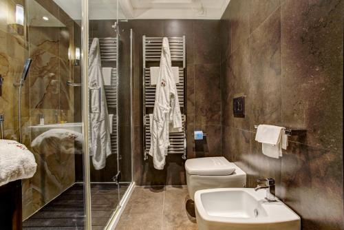 a bathroom with a toilet and a sink and a shower at Hotel Byron in Rimini