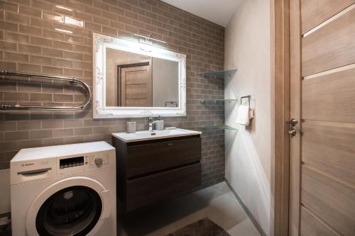 a bathroom with a washing machine and a sink at Old Riga Dome Square Apartment in Riga