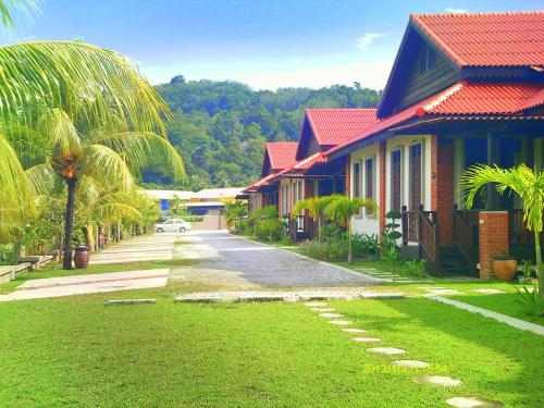 une rangée de maisons avec des palmiers dans une rue dans l'établissement Jasmine Villa, à Pantai Cenang