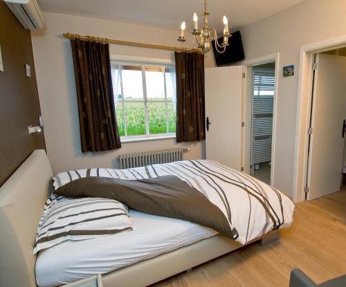 a large bed in a room with a window at De Zilveren Helm in Halen