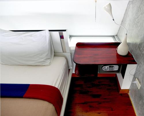 a bedroom with a bed and a table with a lamp at Phuket Paradiso in Chalong 