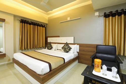 a bedroom with a bed and a desk and a chair at Hotel Loyal Residency in Jamnagar