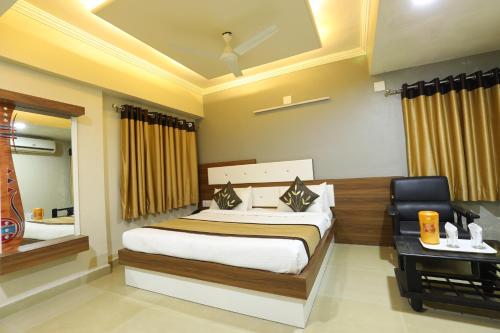 a bedroom with a bed and a desk with a chair at Hotel Loyal Residency in Jamnagar