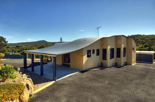 a small building with a roof on a lot at Mayakitana ~ Overlooking the golf course in Coles Bay