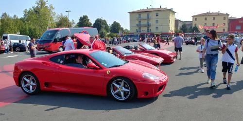 a row of red cars parked in a parking lot at R&B Il Melograno in Formigine