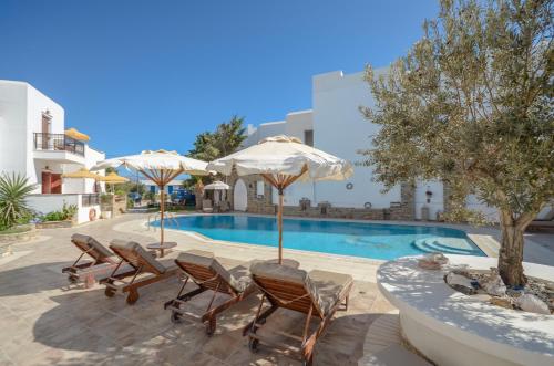 a swimming pool with chairs and umbrellas in front of a building at Summer Dream II in Agia Anna Naxos