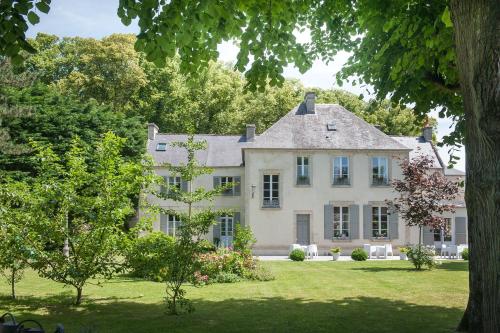 uma grande casa branca com árvores em frente em Le Petit Matin em Bayeux