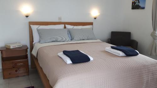 a bedroom with a large bed with two towels on it at Rodis Studios in Tsilivi
