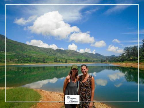 two women standing in front of a lake with a sign at Princess of Dickoya Homestay in Hatton
