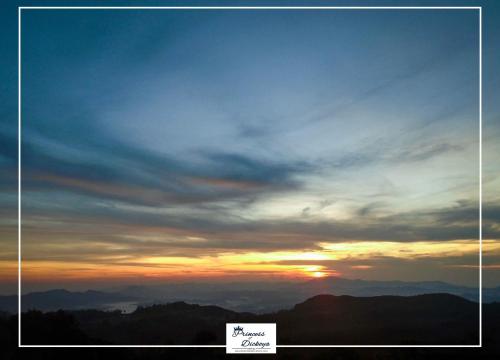 a sunset in the mountains with a cloudy sky at Princess of Dickoya Homestay in Hatton