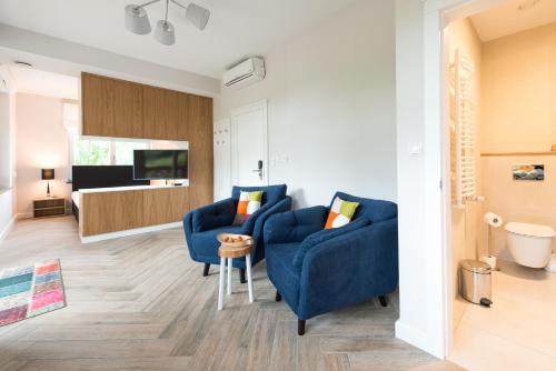 a living room with two blue chairs and a television at Apartamenty Panorama Szczawnica in Szczawnica
