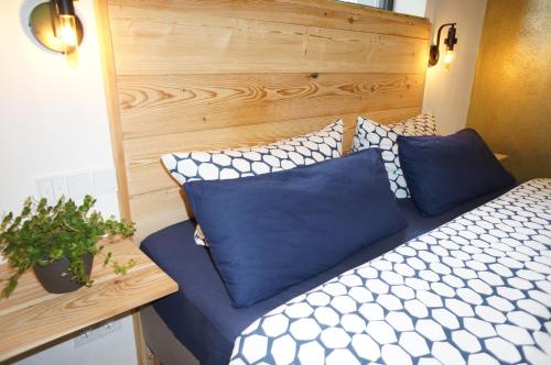 een bed met blauwe en witte kussens in een kamer bij Hey Spreewald Ferienapartments in Lübben