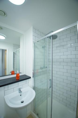 a bathroom with a sink and a glass shower at Fox Street Studios in Liverpool