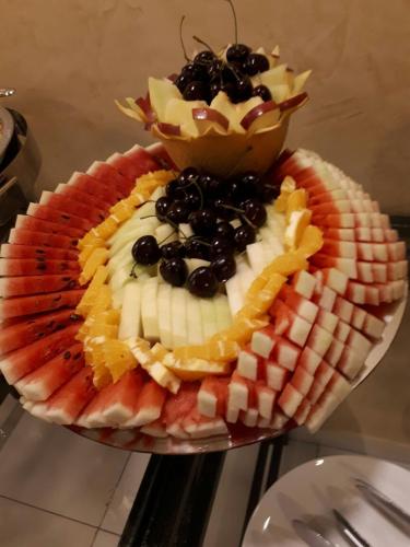 a plate of food with fruit and a bowl of cherries at City Rose Hotel Suites in Amman