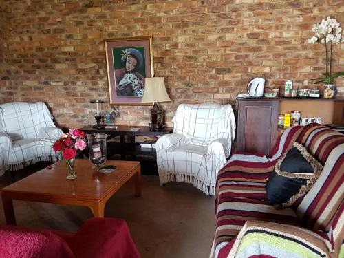 a living room with two couches and a brick wall at MyAula in Tierpoort