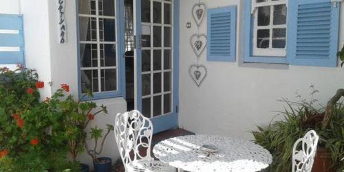 a table and chairs in front of a house at Eastbury Cottage in Hermanus