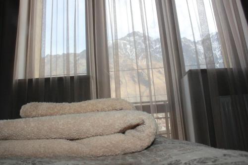 una camera con un letto e una grande finestra di Hotel Gergeti a Kazbegi