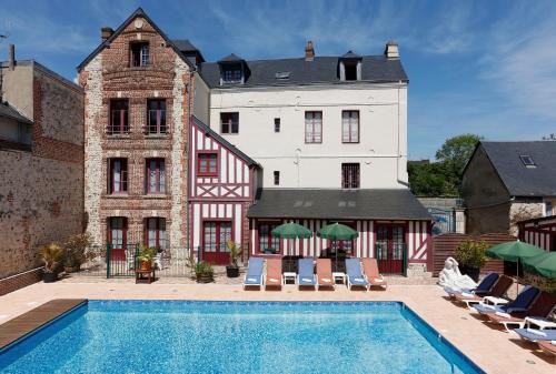 un hôtel avec une piscine devant un immeuble dans l'établissement Hôtel L'Ecrin, à Honfleur