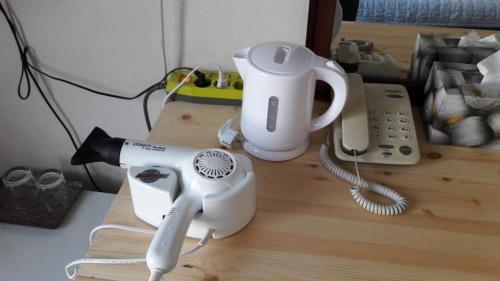 a hair dryer and a phone on a table at Minjoonggak in Seogwipo