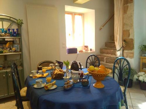 プリヴァにあるMoulin De Cornevis Bed and Breakfastの青いテーブルクロスと果物をテーブルに載せたテーブル