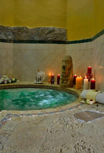 a swimming pool with candles and a statue in a room at Hotel Hacienda El Salitre in Paipa