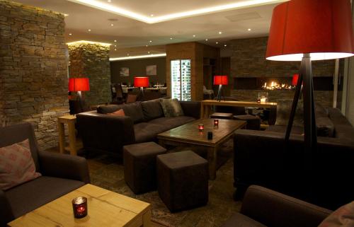 a living room with a couch and chairs and a table at Hotel Crown in Andermatt