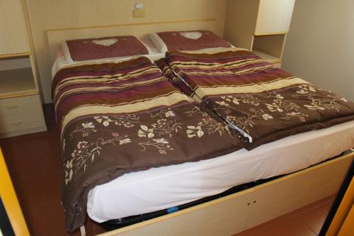 2 łóżka w małym pokoju z kocami w obiekcie Appartamento San Bartolomeo w mieście Passo del Tonale