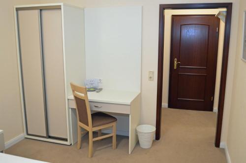 a room with a desk and a chair and a door at G&H Hotel Rosengarten in Rosengarten