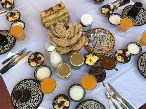un tavolo con piatti di cibo e bicchieri di succo d'arancia di Riad Safa a Marrakech