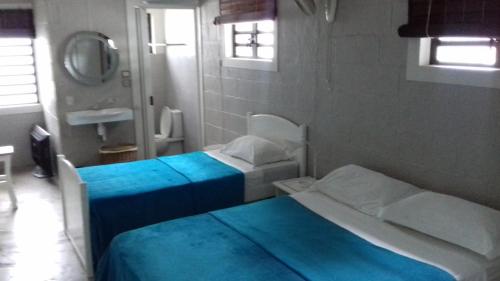two beds in a small room with a mirror at La grange de G. in Grand Gaube
