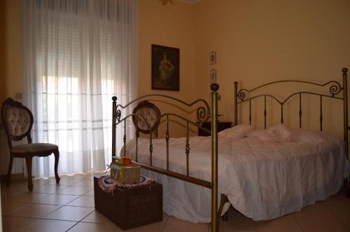 um quarto com uma cama, uma cadeira e uma janela em Enzo's Homestay em Gaggi