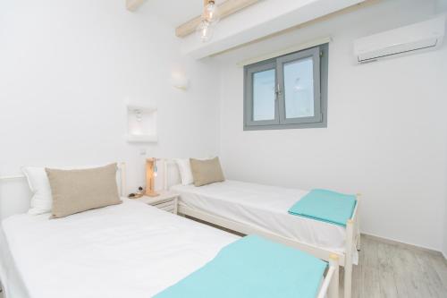 a room with two beds and a window at Salinus Beachfront Private Pool Villas in Plaka