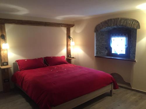 sypialnia z czerwonym łóżkiem i oknem w obiekcie La Boule de Neige w mieście Pré-Saint-Didier