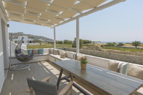 a patio with a wooden table and chairs at Salinus Beachfront Private Pool Villas in Plaka