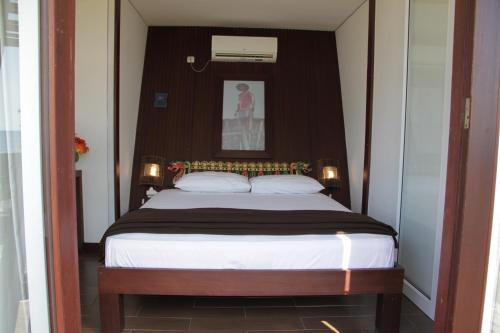 Un pat sau paturi într-o cameră la Bali Umah Tinjung