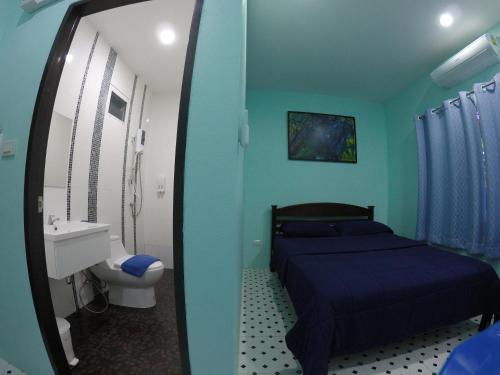 a blue bedroom with a bed and a sink and a mirror at Phuket Best Travel in Nai Yang Beach