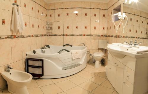a bathroom with a tub and a sink and a toilet at Hotel Aramia in Satu Mare