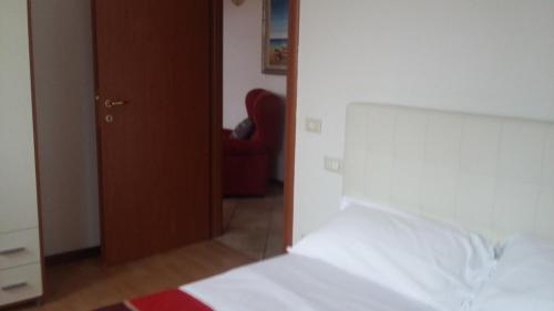 ヴィチェンツァにあるalloggi Alba 1のベッドルーム(白いベッド1台、赤い椅子付)