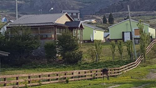 a house in a field with a fence at Complejo "Nahuel Pan " in El Chalten