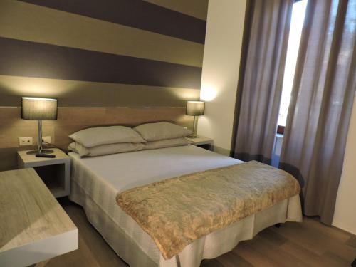 une chambre avec un grand lit et deux lampes dans l'établissement san cosimato suite, à Rome
