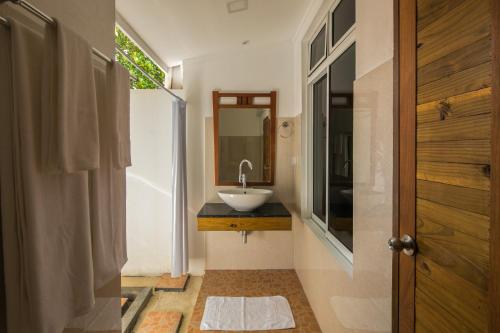 a bathroom with a sink and a mirror at Holiday Garden Rasdhoo in Rasdu