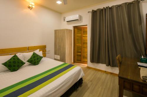 een slaapkamer met een bed, een bureau en een raam bij Holiday Garden Rasdhoo in Rasdu