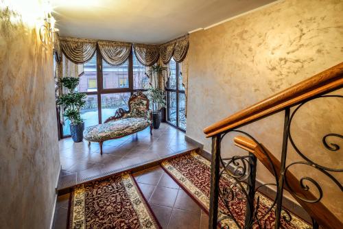 Habitación con escalera, silla y ventana. en Hotel Aramia, en Satu Mare